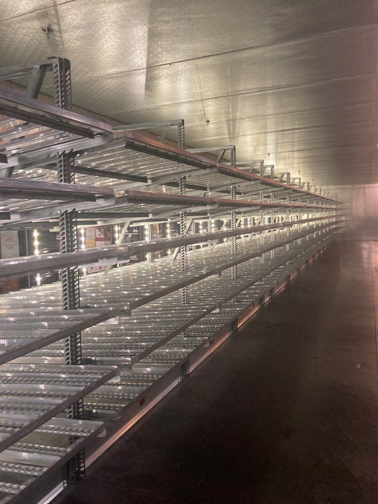 A long row of empty shelves in a warehouse.