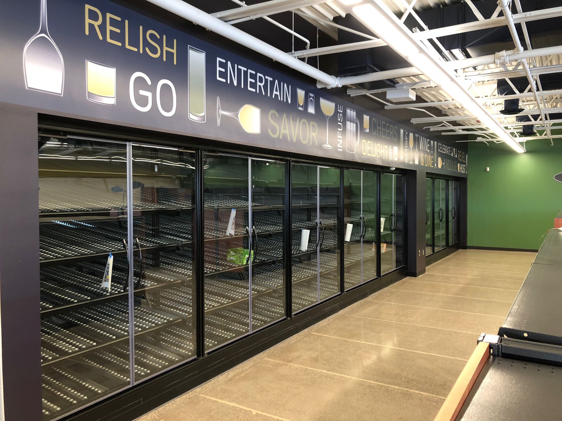 An empty grocery store with a sign that says relish entertain go