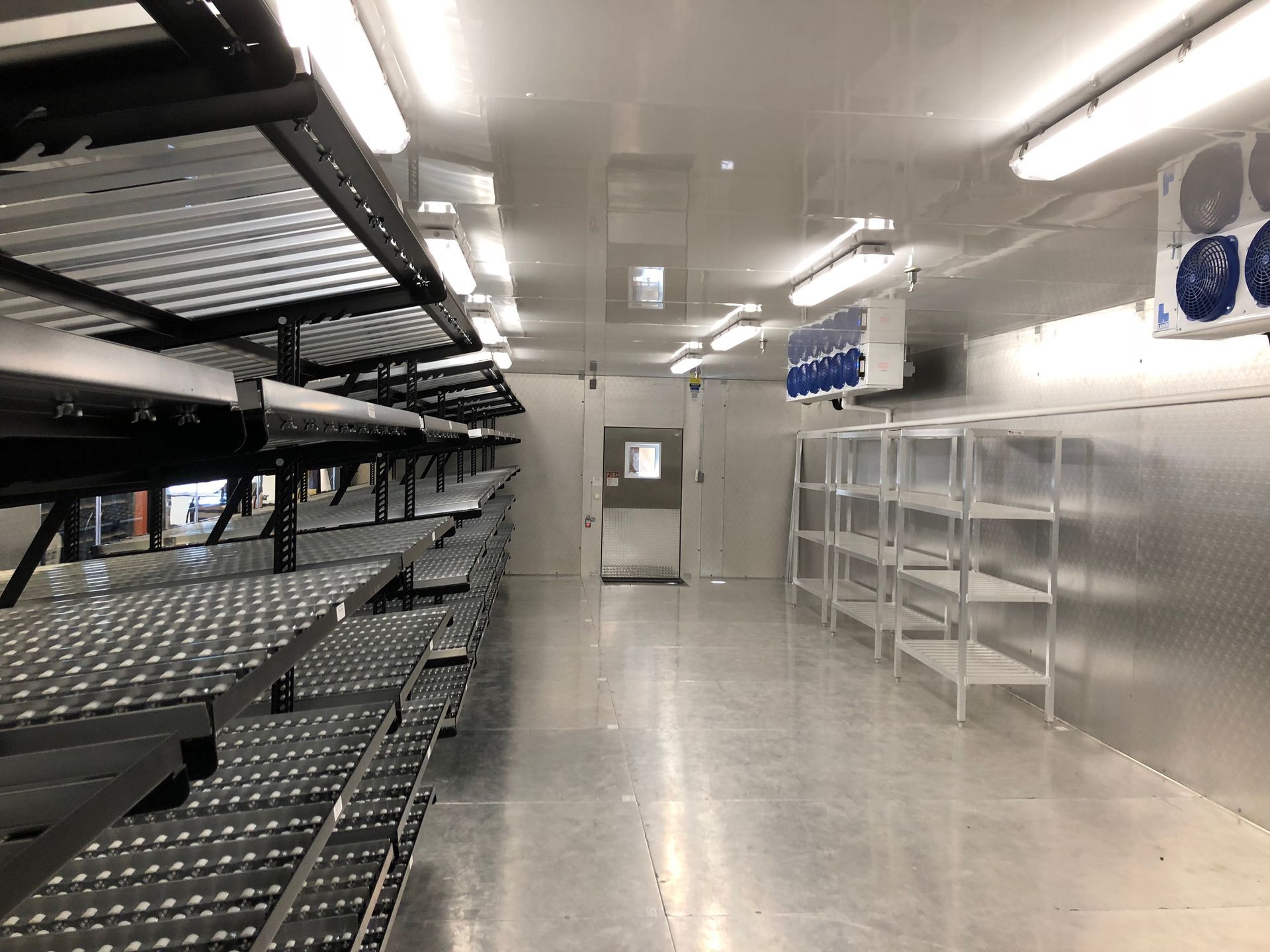 A large room with a lot of shelves and a door.