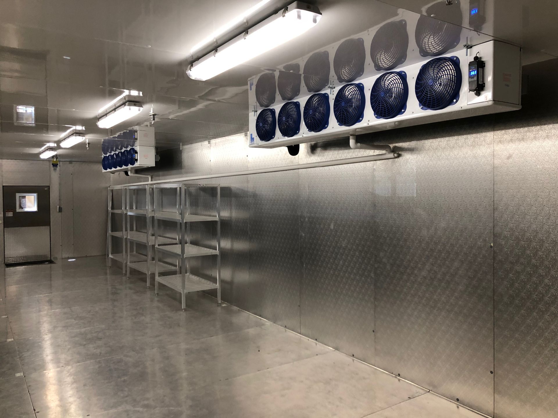 A large room with a lot of shelves and fans on the wall.