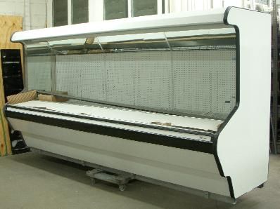 A large white refrigerator is sitting on the floor in a room.