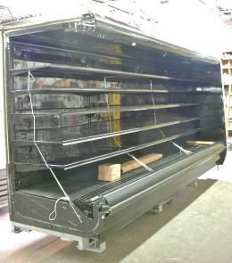 An empty refrigerator with the door open in a warehouse