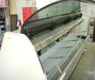 A large refrigerator with a glass door is sitting in a room.