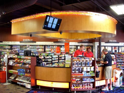 A man is standing at a counter in a grocery store.