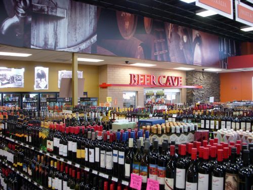 A store filled with lots of wine bottles and a sign that says beer cave