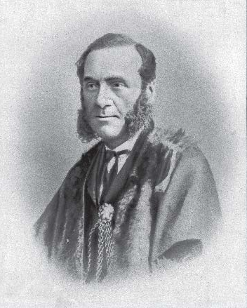 Portrait of a man wearing a formal suit, with a small beard and a serious expression.