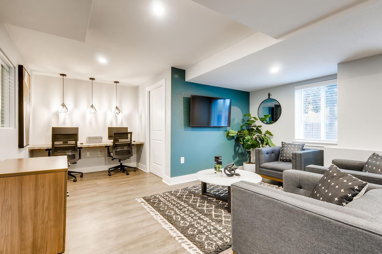 Interior community lounge with teal accent wall, TV, and seating area.