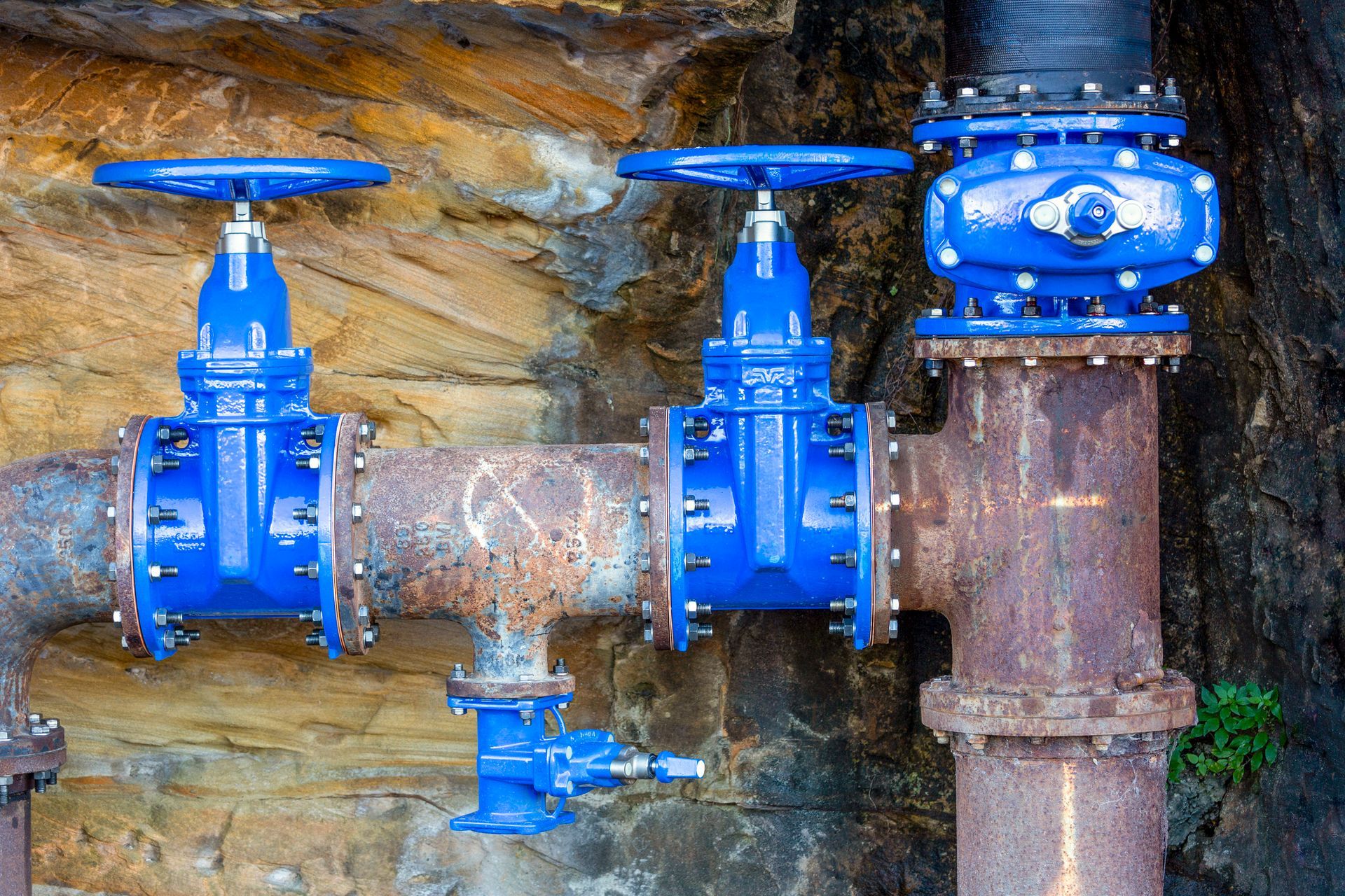A close-up of plumbing tools, connectors, and a wrench arranged on a blueprint.