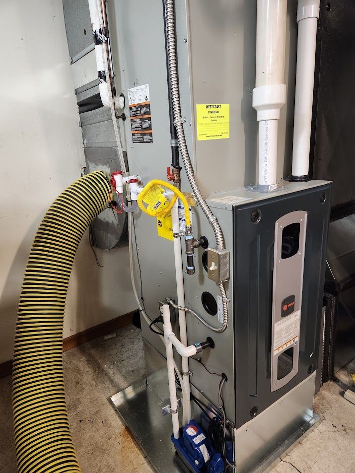 Gray furnace and water heater in a basement utility room.