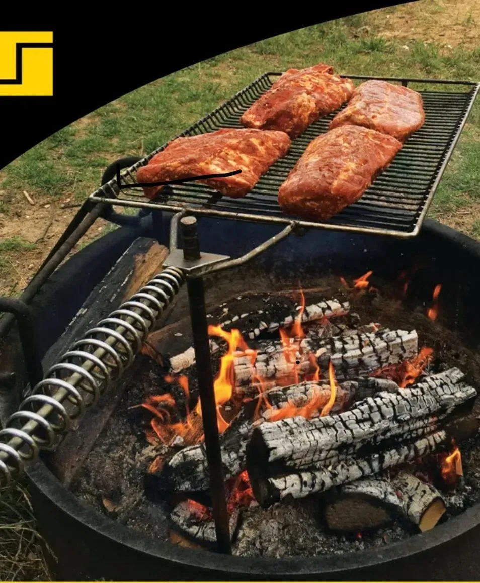 Four seasoned meat cuts grill over an open fire pit on a metal grate with a spring-coiled handle.