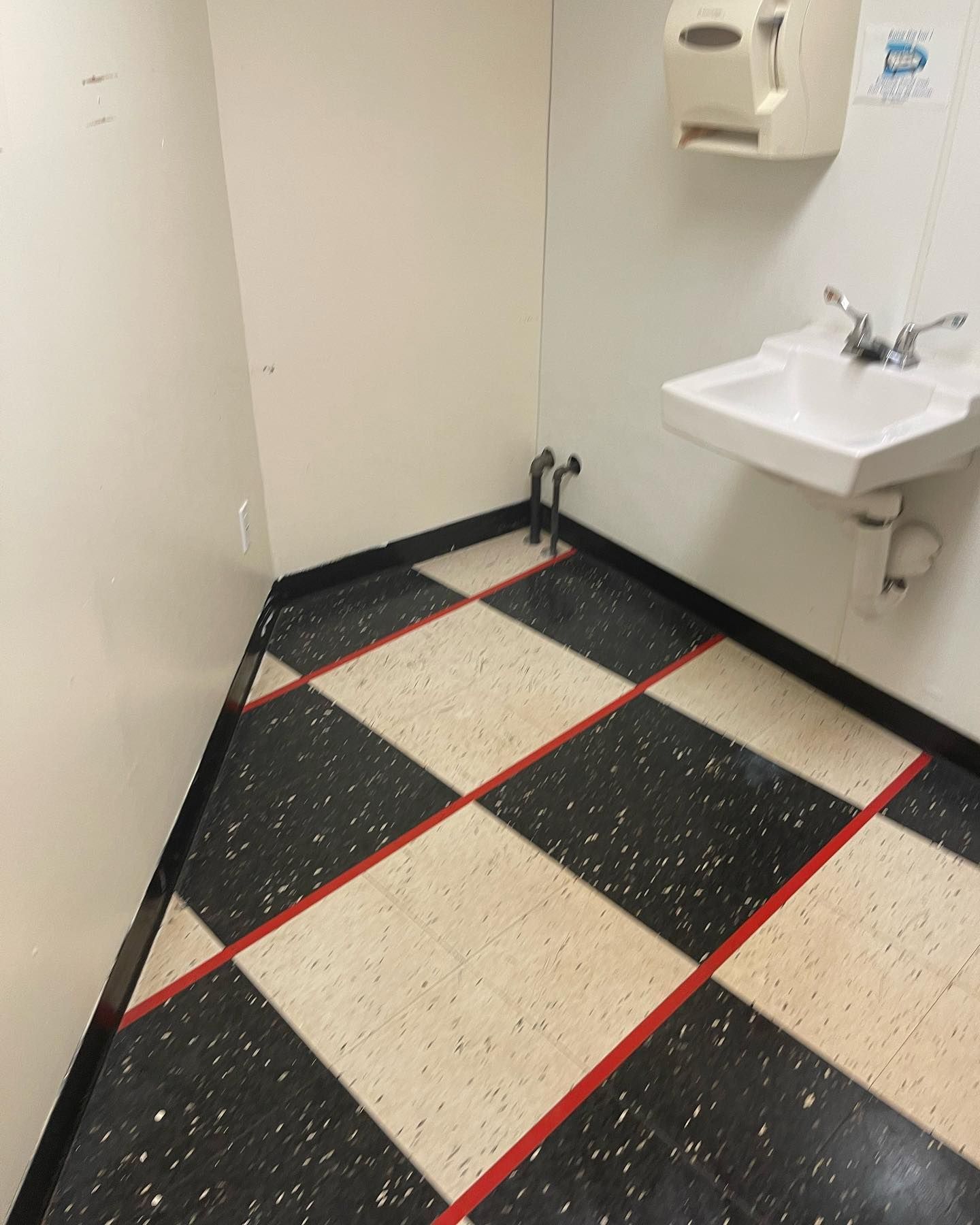 After image of a bathroom with a checkered floor and a sink that sparkle and all stain on the floor was removed
