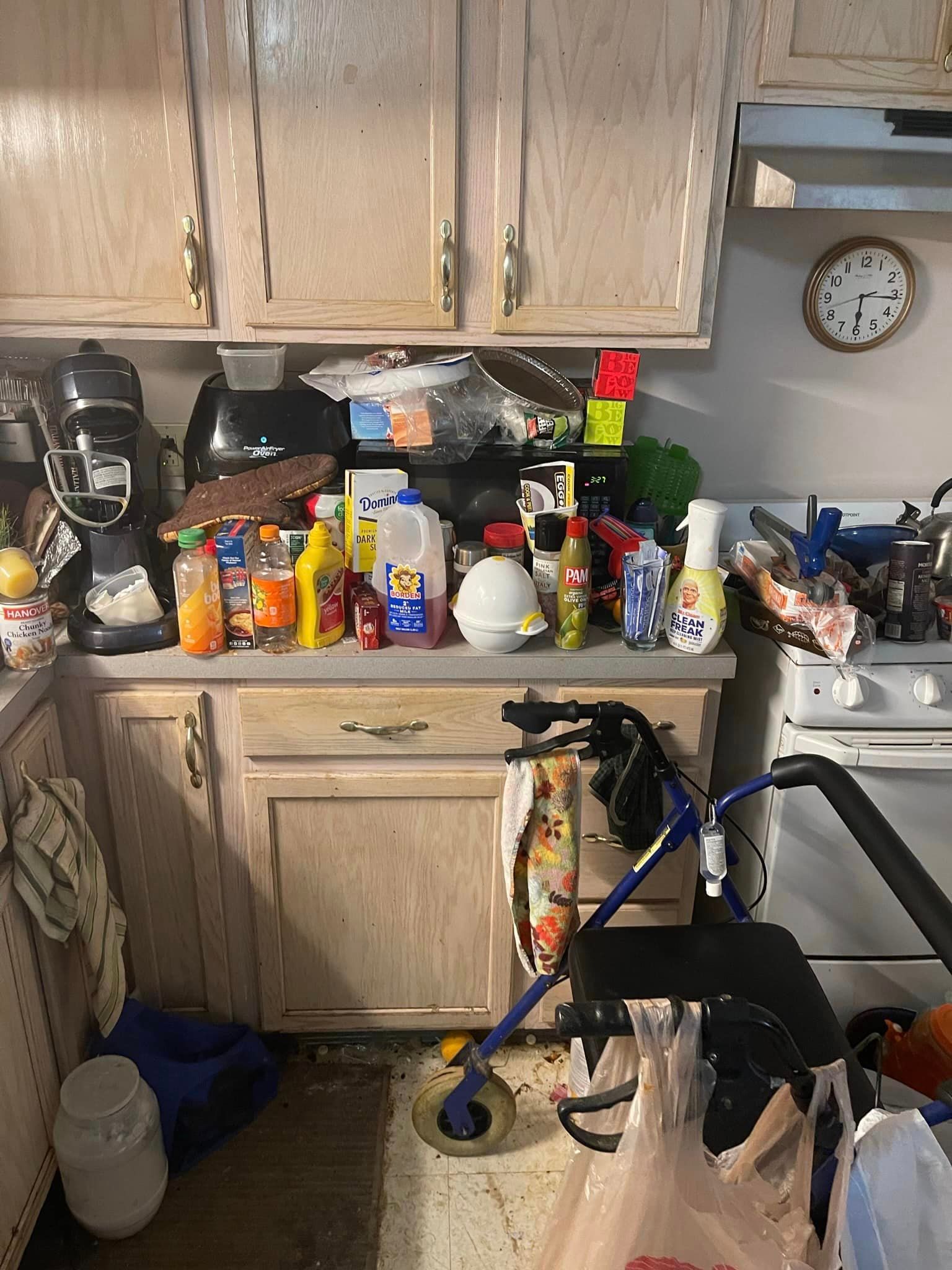 Before is a dirty kitchen with a lot of products all over the counter and a walker on the floor