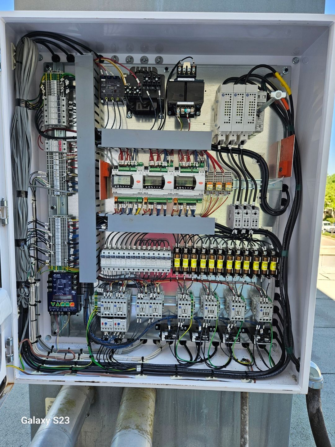 The inside of a electrical box with a lot of wires coming out of it.