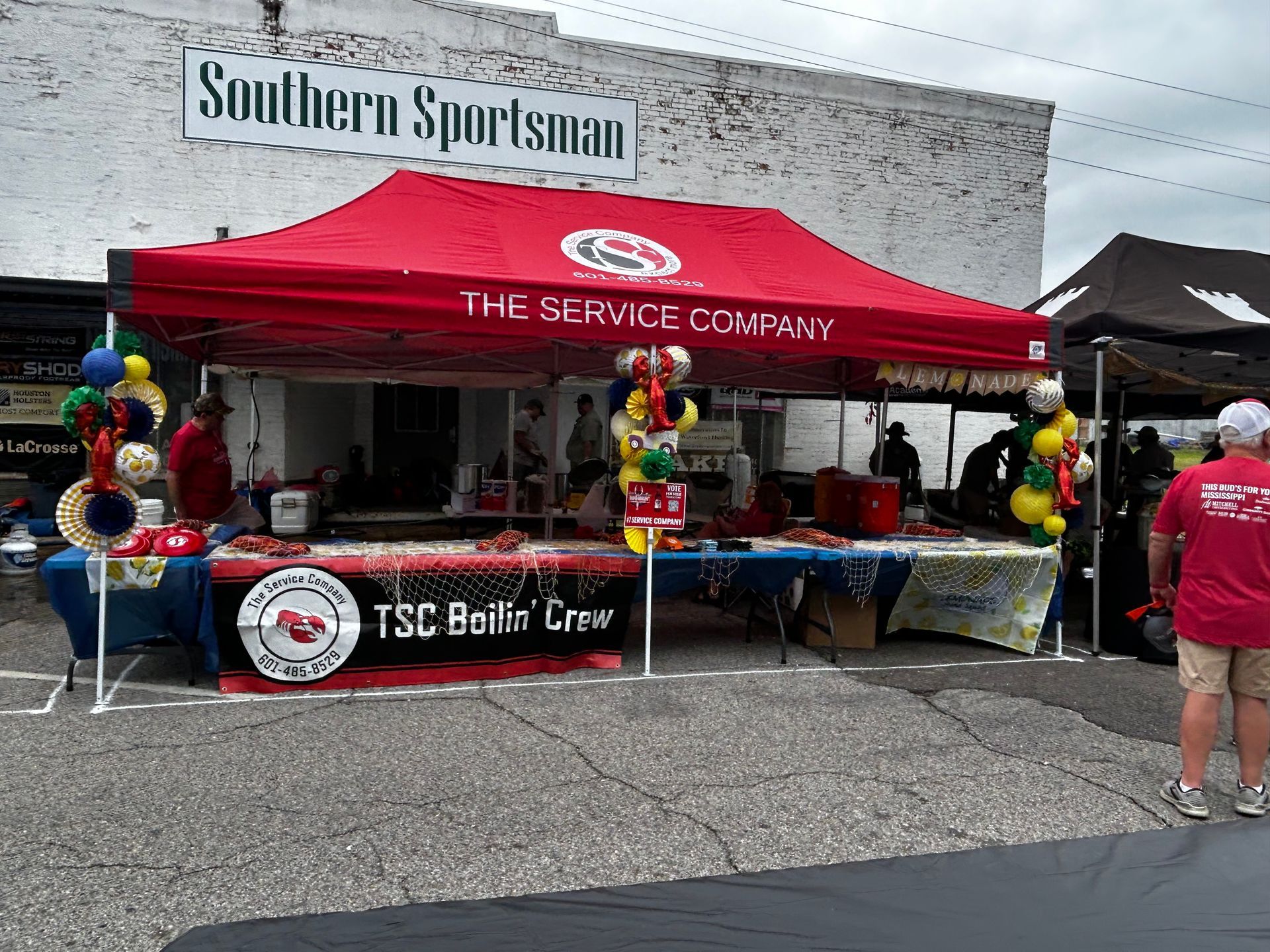 A red tent is sitting in front of a building that says southern sportsman.