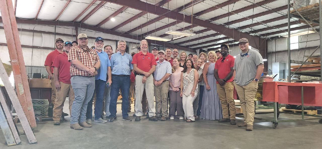 A group of people are posing for a picture in a warehouse.