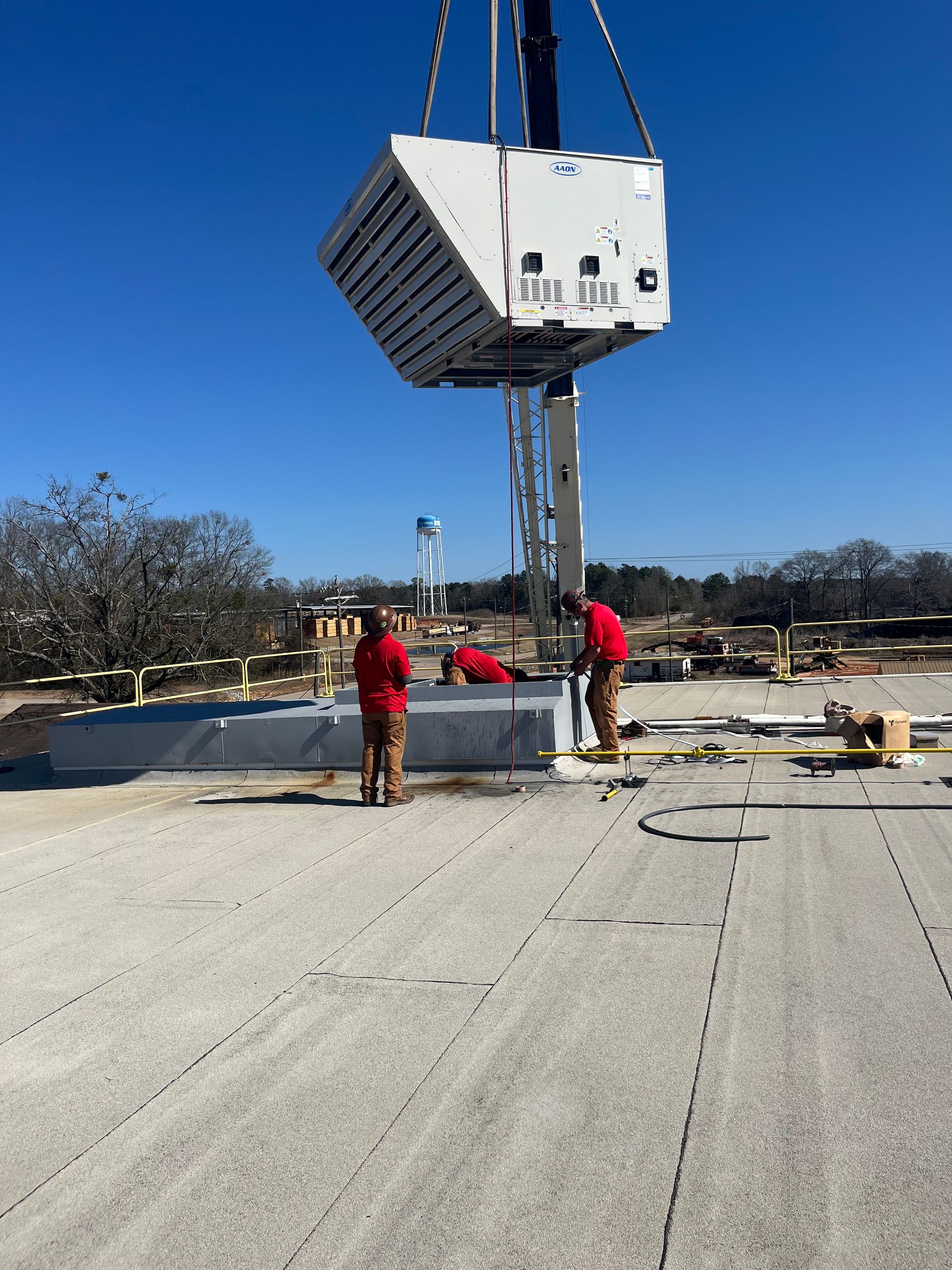 Two men are working on a roof with a crane