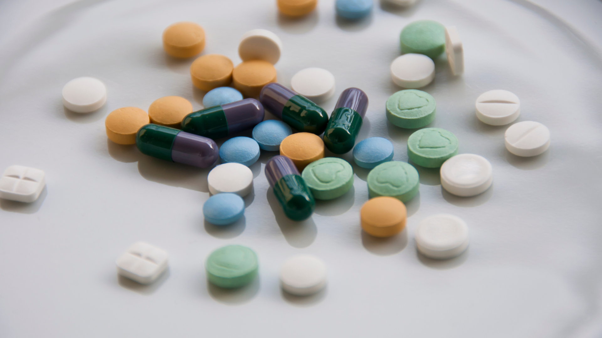 a white plate topped with a variety of pills and capsules .