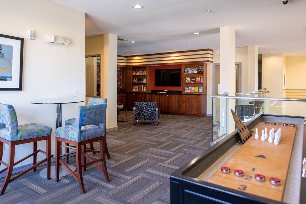 There is a shuffleboard table in the middle of the game room at 82 Flats.