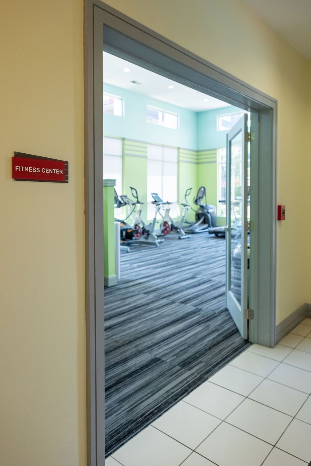 A hallway leading to a gym with exercise bikes at 82 Flats.