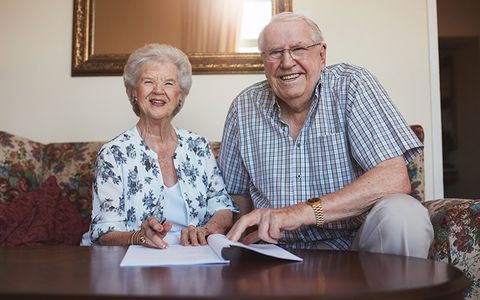Smiling Retired Couple Looking over documents - The Umbrella Insurance in Bowie, MD