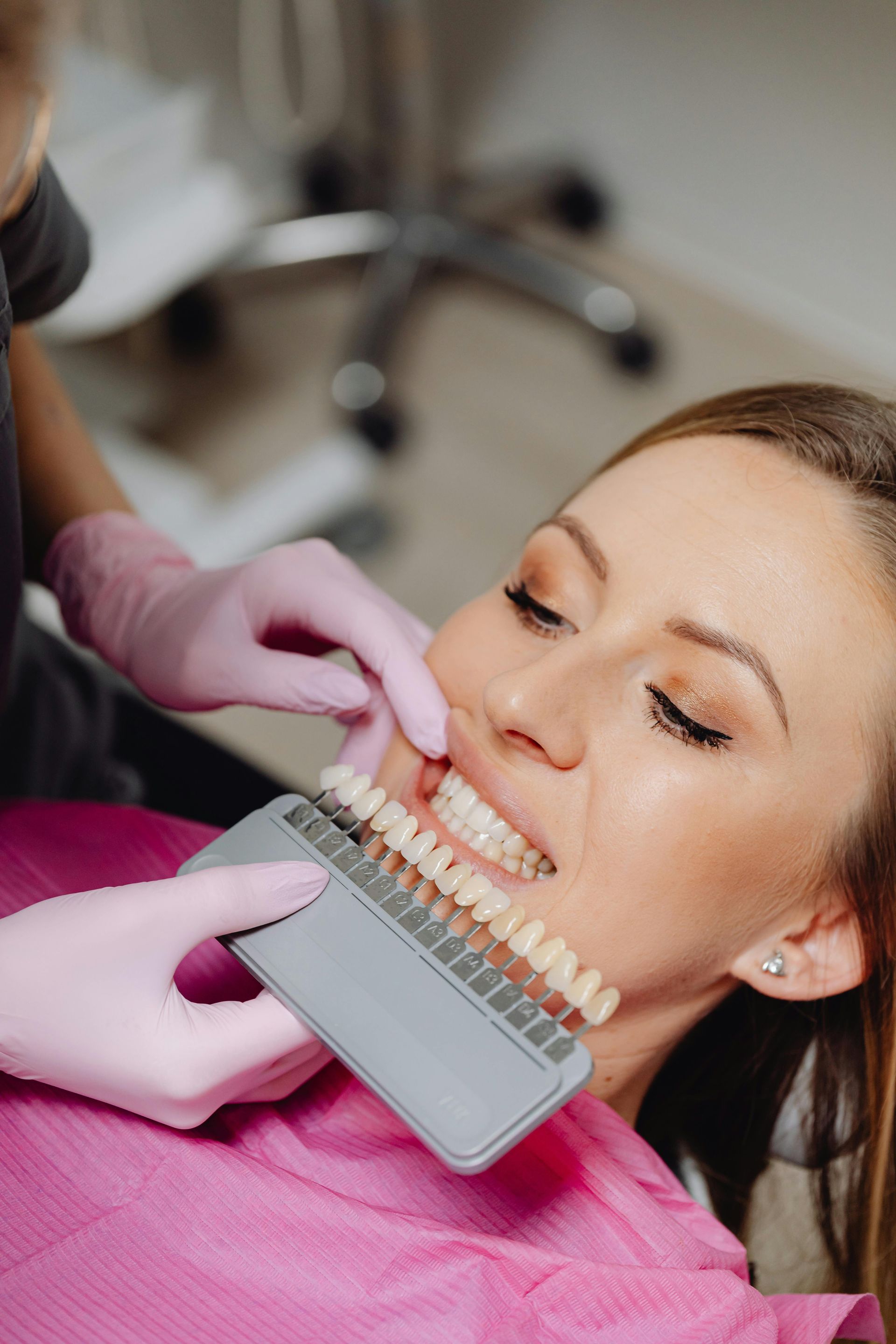 A woman is getting her teeth whitened at the dentist.