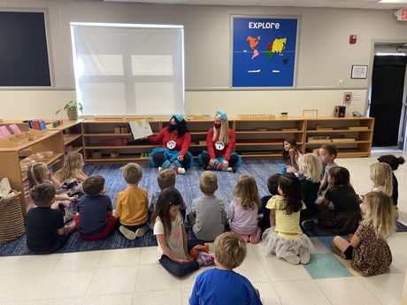 A group of child and guide working together in a Montessori classroom