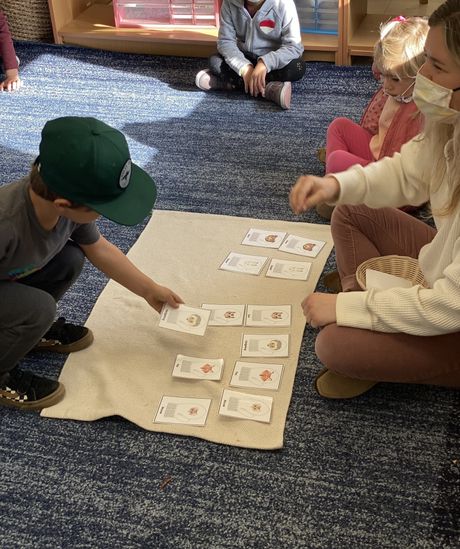 A child and guide working in a Montessori classroom