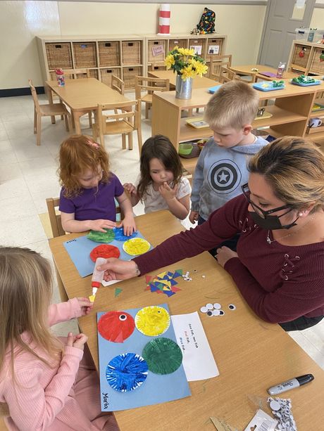 A group of child and guide working together in a Montessori classroom