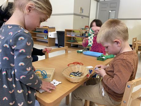 A group of child  working together with Montessori materials