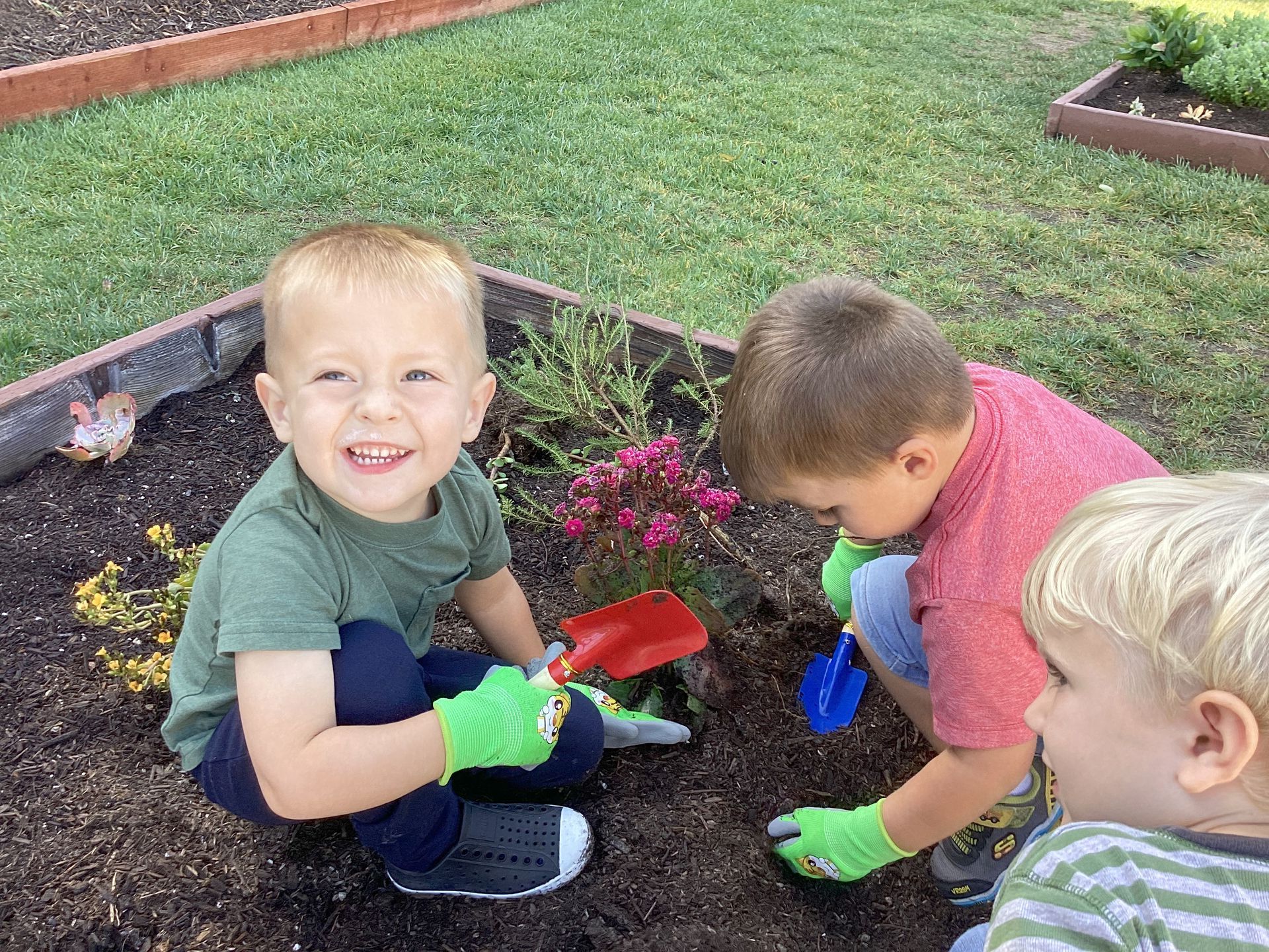 Two Montessori child are playing in the garden.