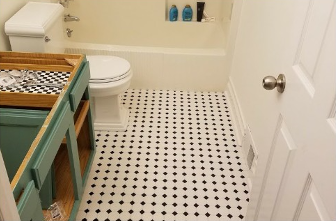 A bathroom with a black and white tile floor
