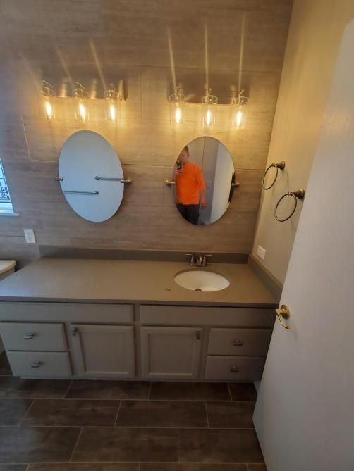 A bathroom with two mirrors and a sink.
