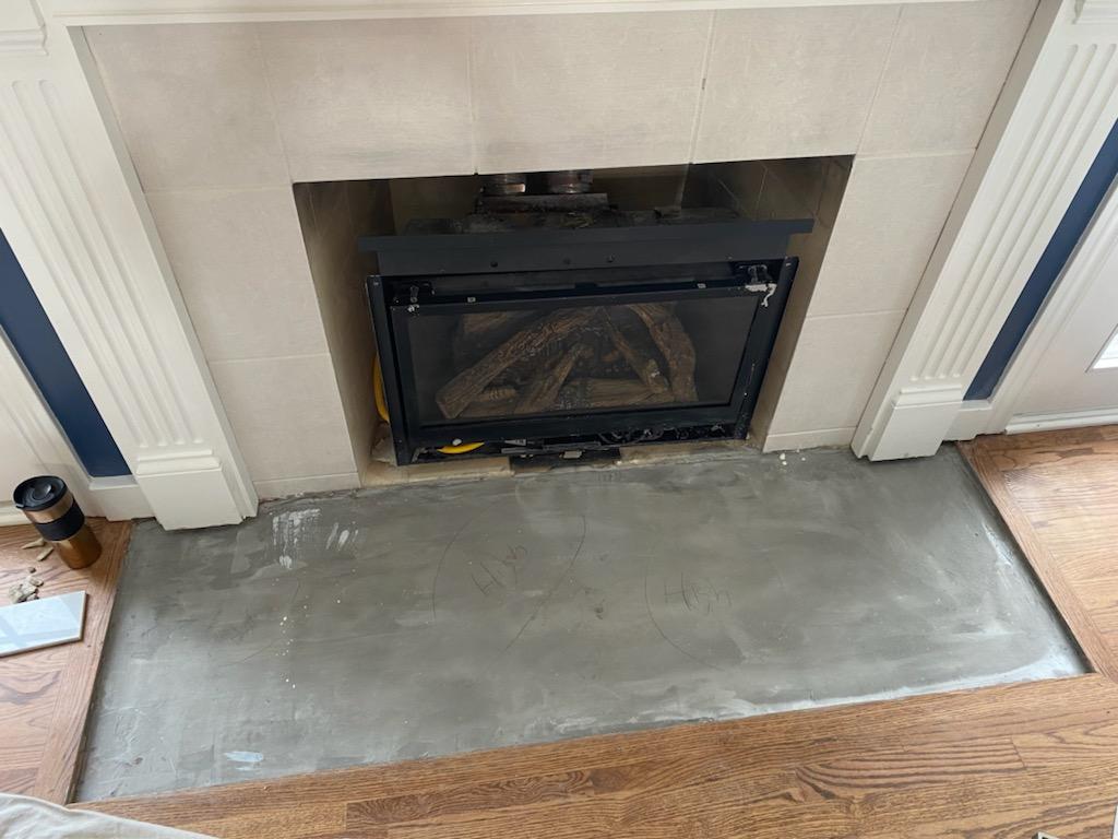 A fireplace is being remodeled in a living room.