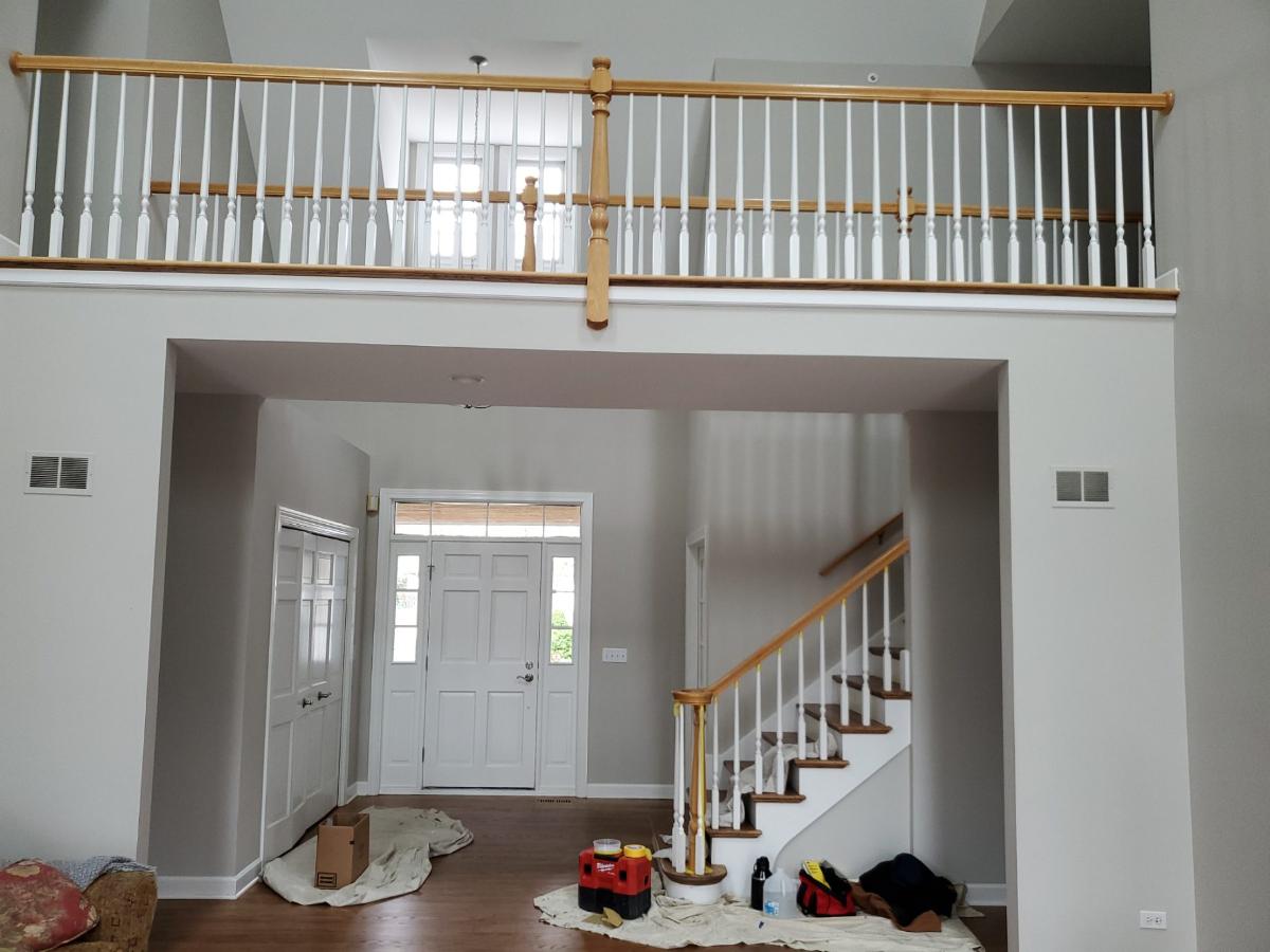 A staircase in a house with a balcony above it