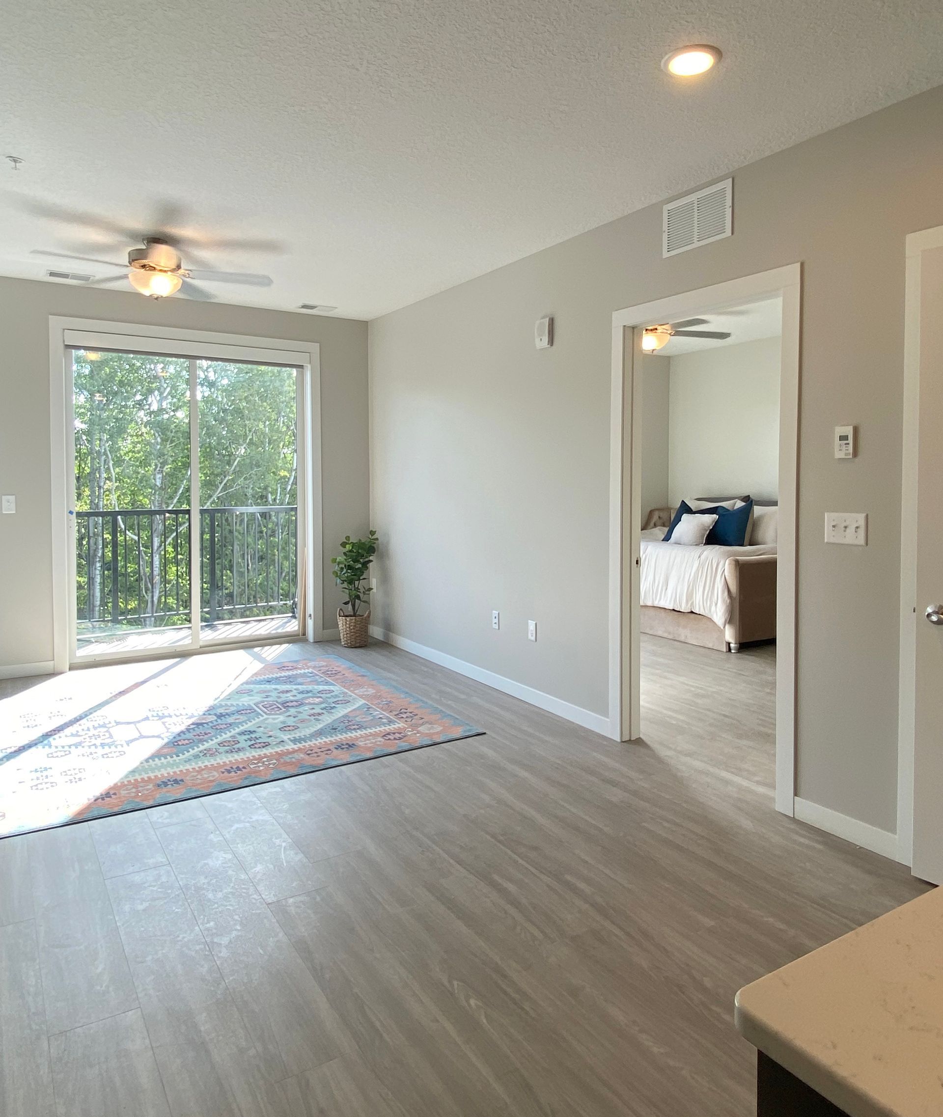 a living room with a sliding glass door leading to a bedroom .