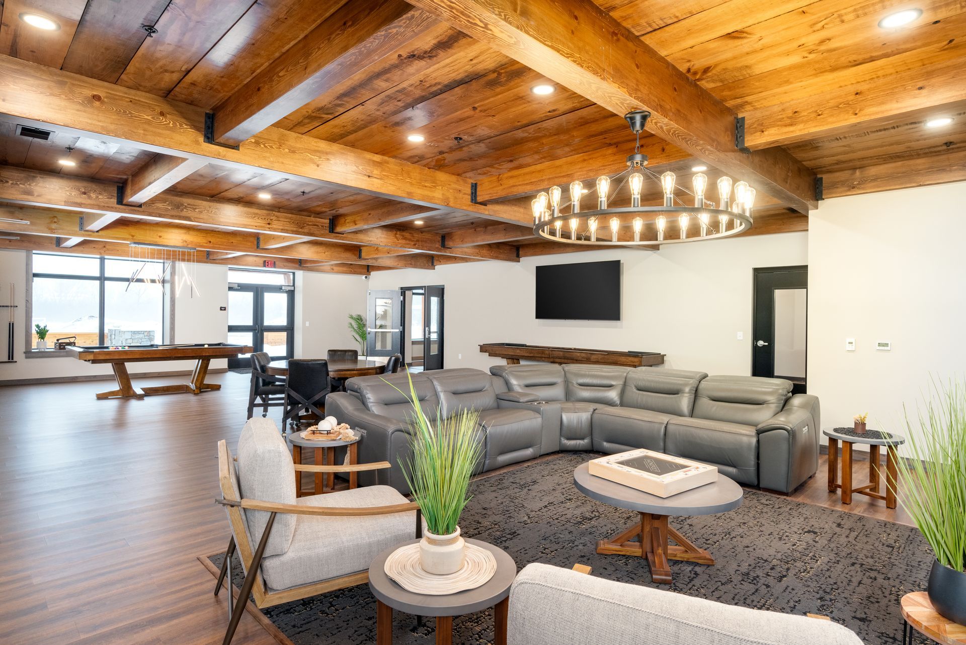 a living room with a couch , chairs , tables and a pool table .
