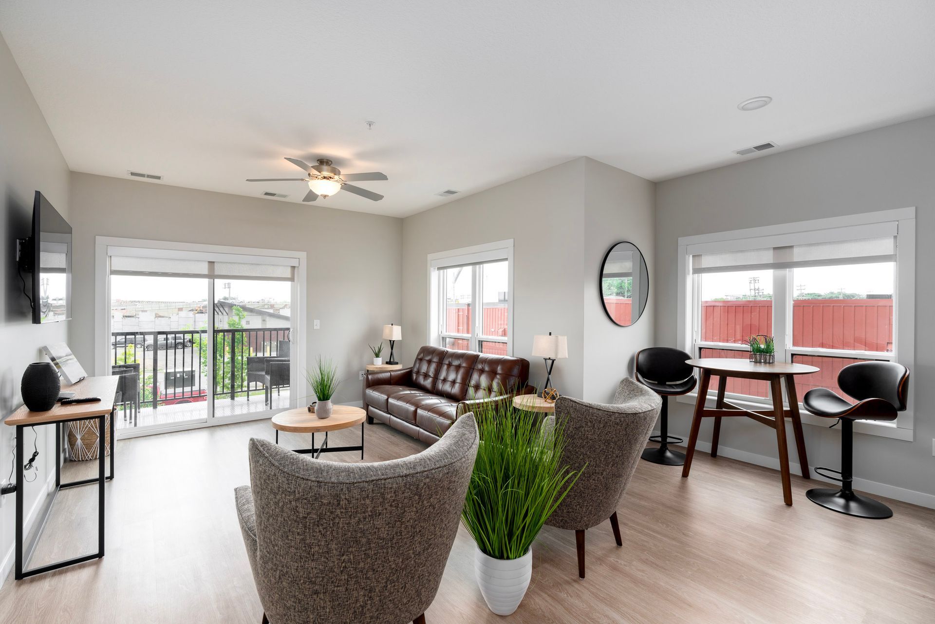 a living room with a couch , chairs , a table and a ceiling fan .