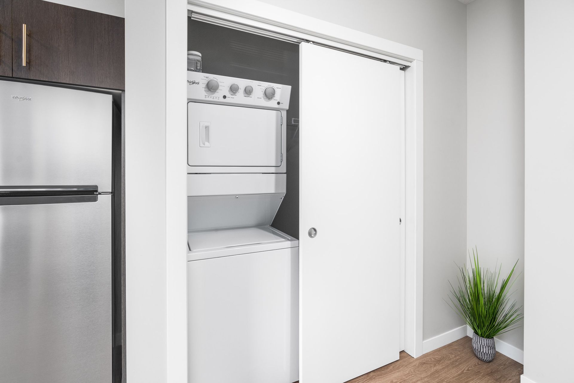 a washer and dryer are in a closet next to a refrigerator .