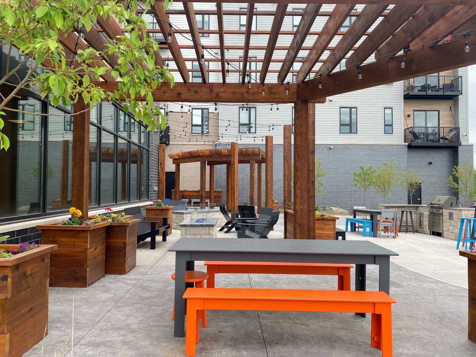 a patio with a table and benches under a pergola .