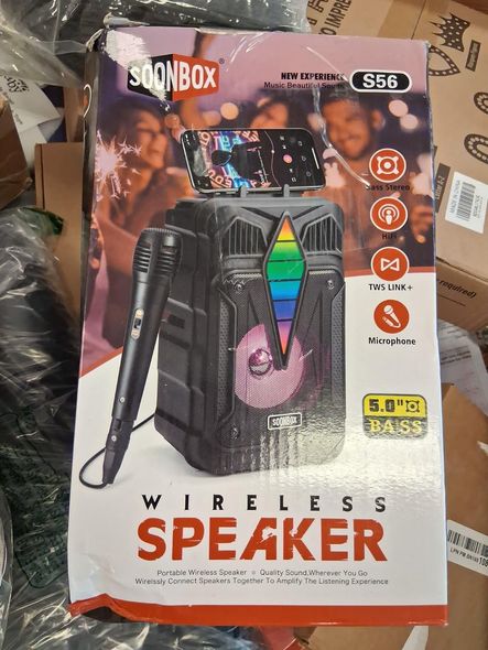 Box of a black wireless speaker with microphone. It has a phone holder, LED lights, and a party scene on the box.