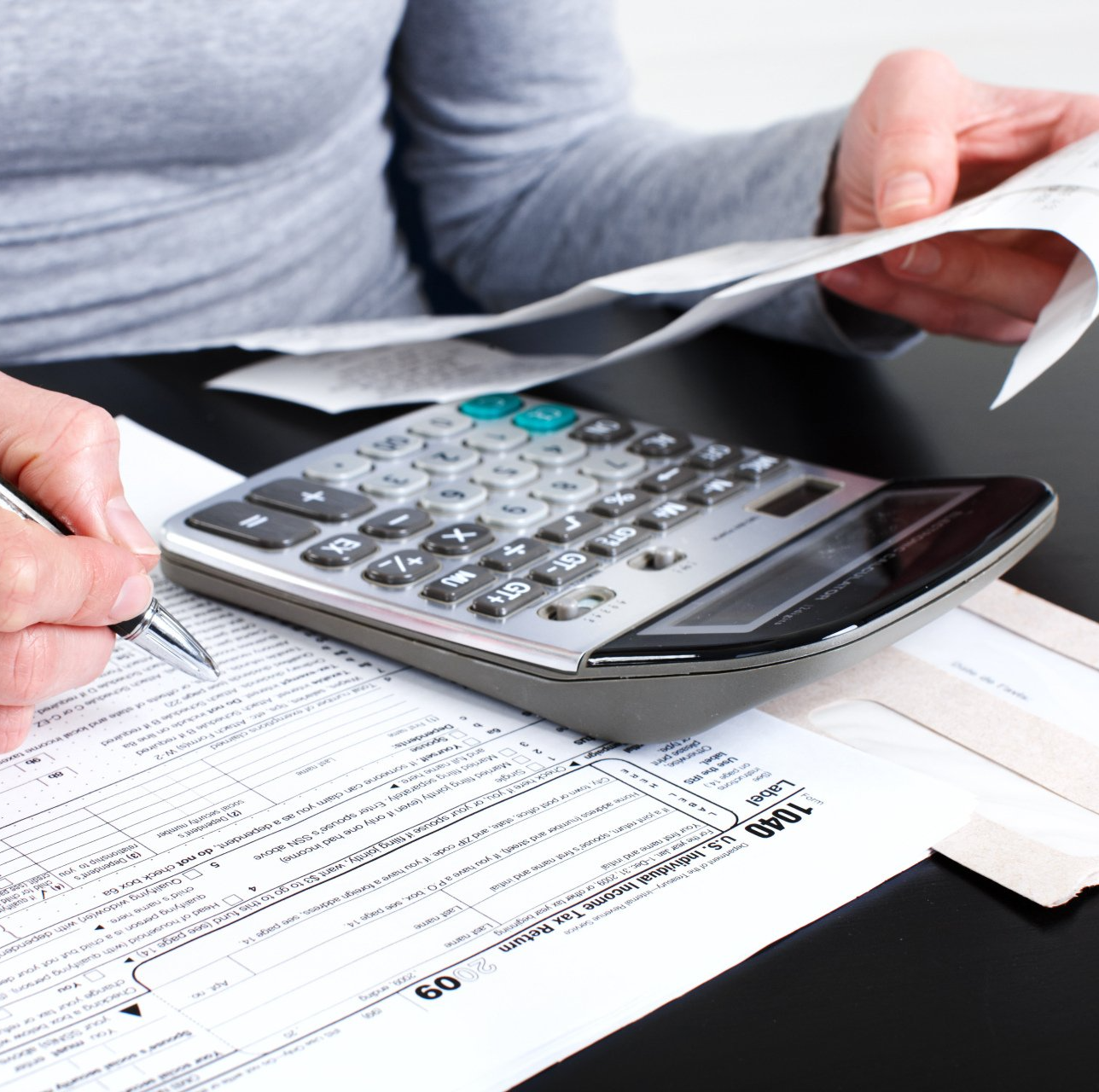 Man Holding A Calculator — Elmhurst, IL — IRS Trouble Solvers, LLC