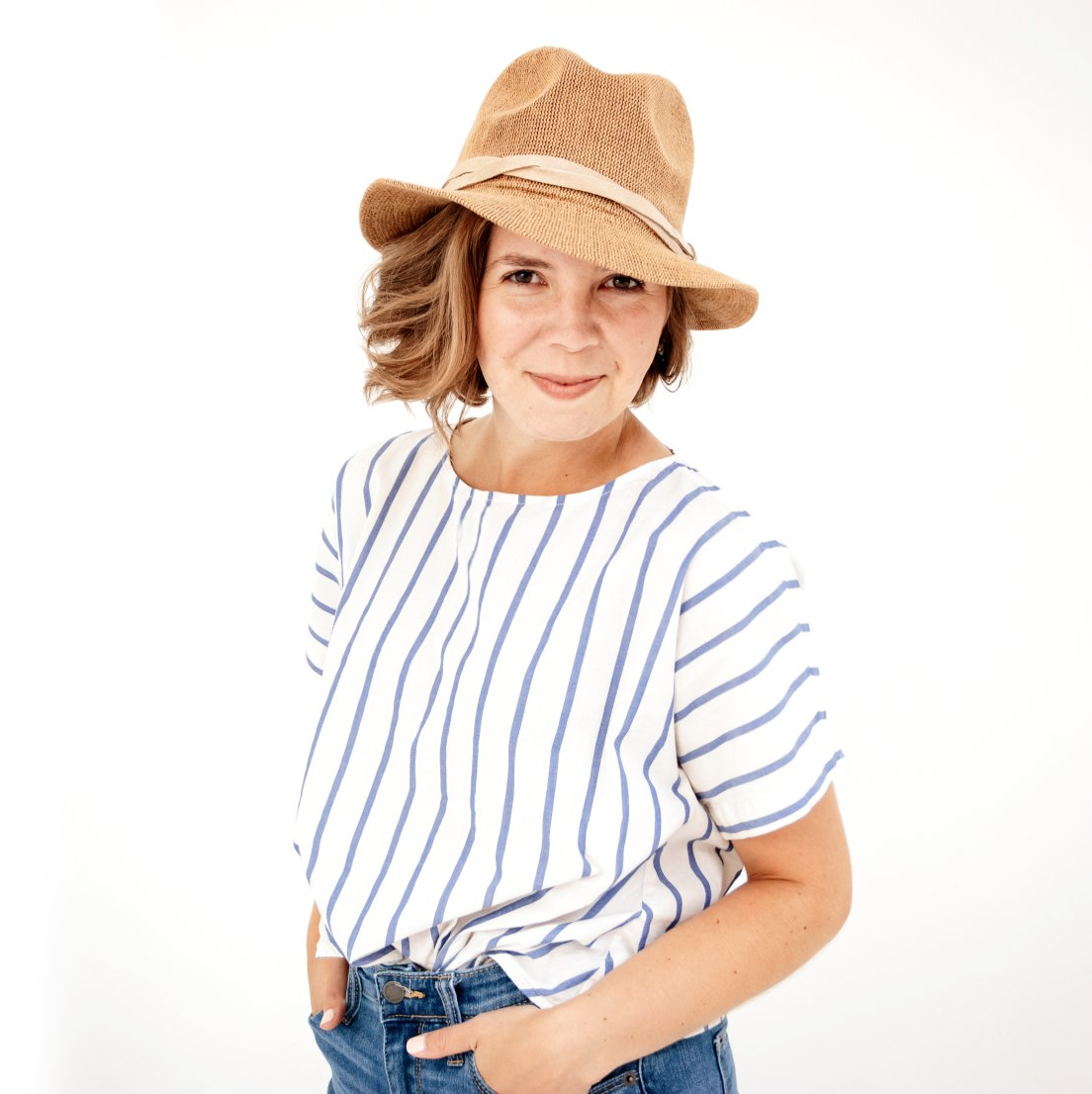 A woman wearing a striped shirt and a straw hat.