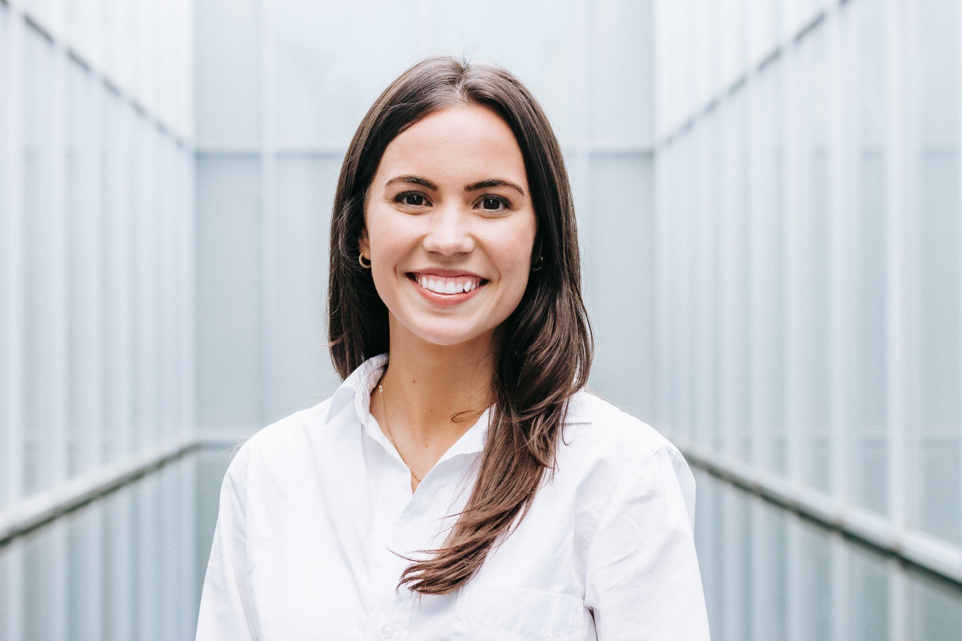 A woman in a white shirt is smiling for the camera.