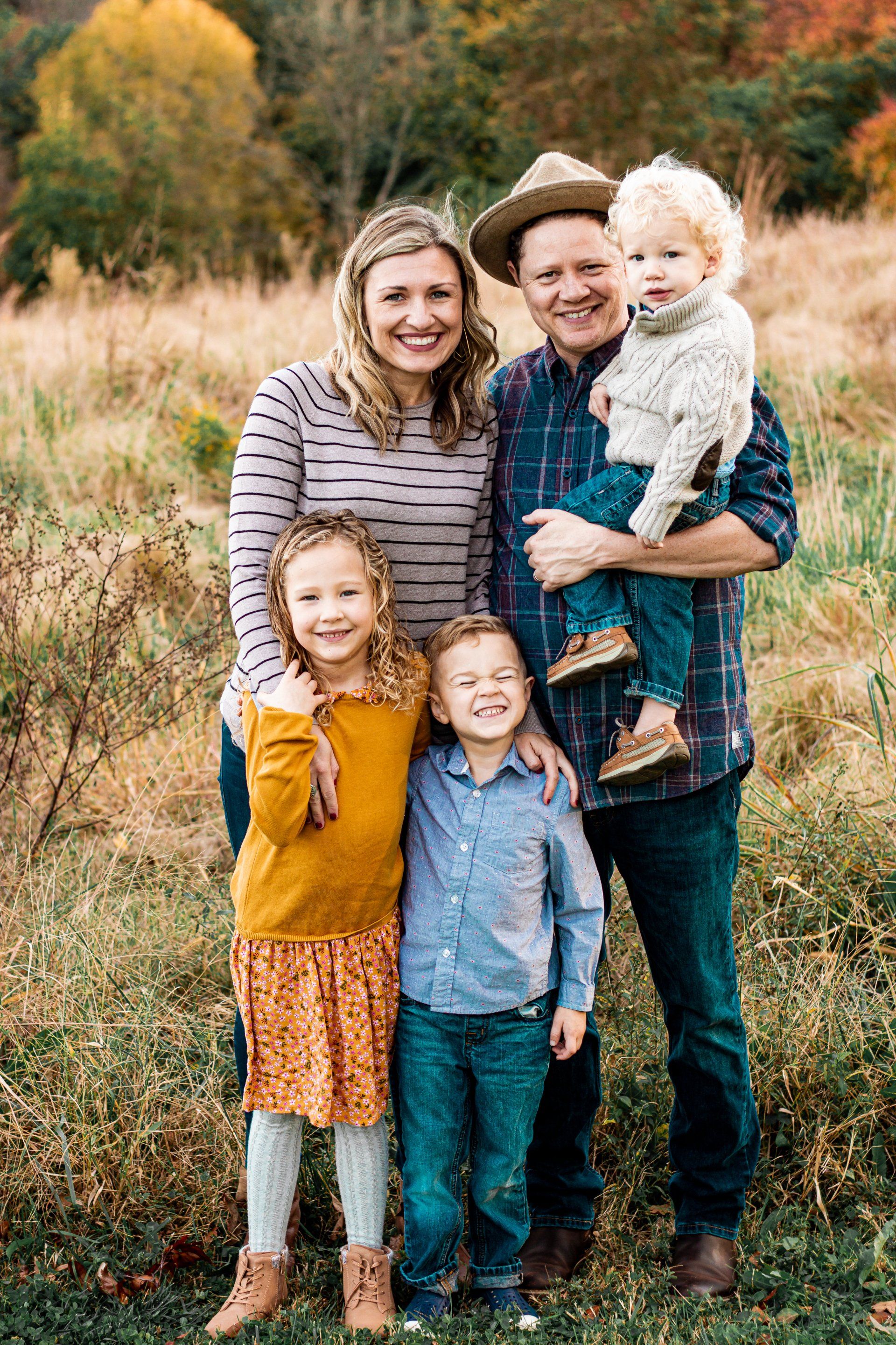A family is posing for a picture in a field.