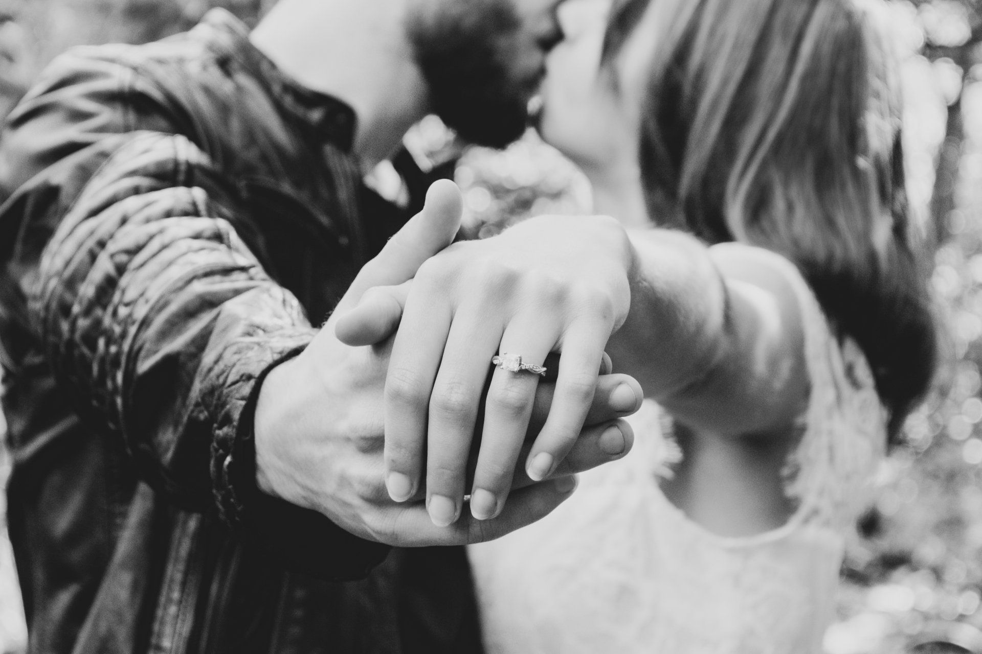 A man is putting an engagement ring on a woman 's finger.