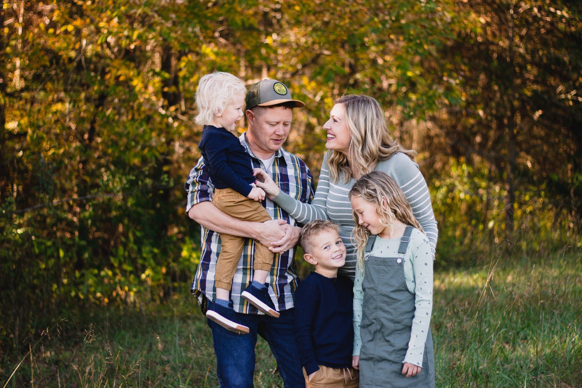 A family is posing for a picture in a field.