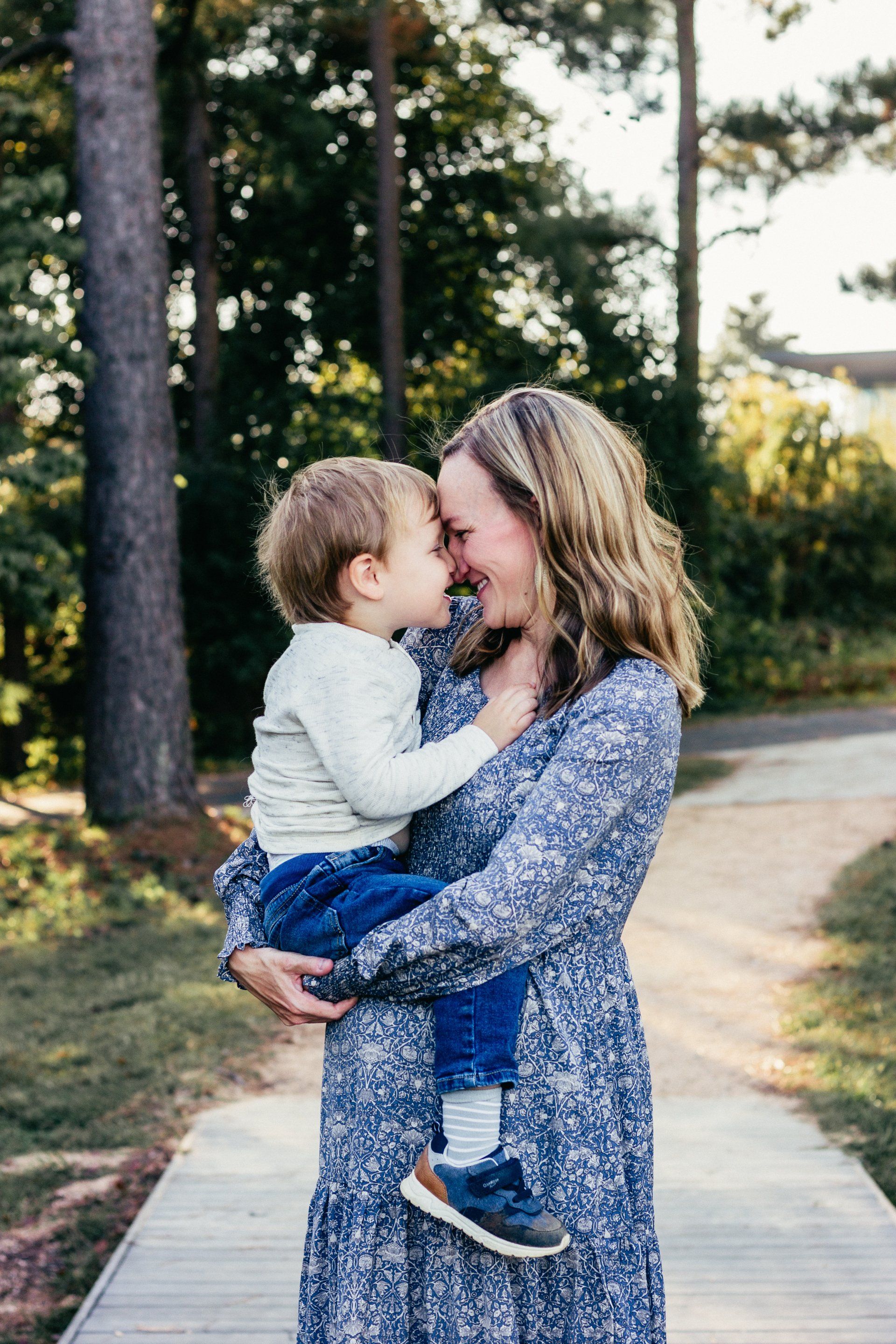 A woman is holding a little boy in her arms.