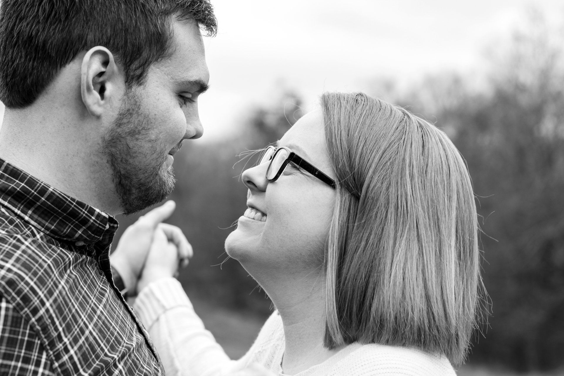 A man and a woman are looking at each other in a black and white photo.
