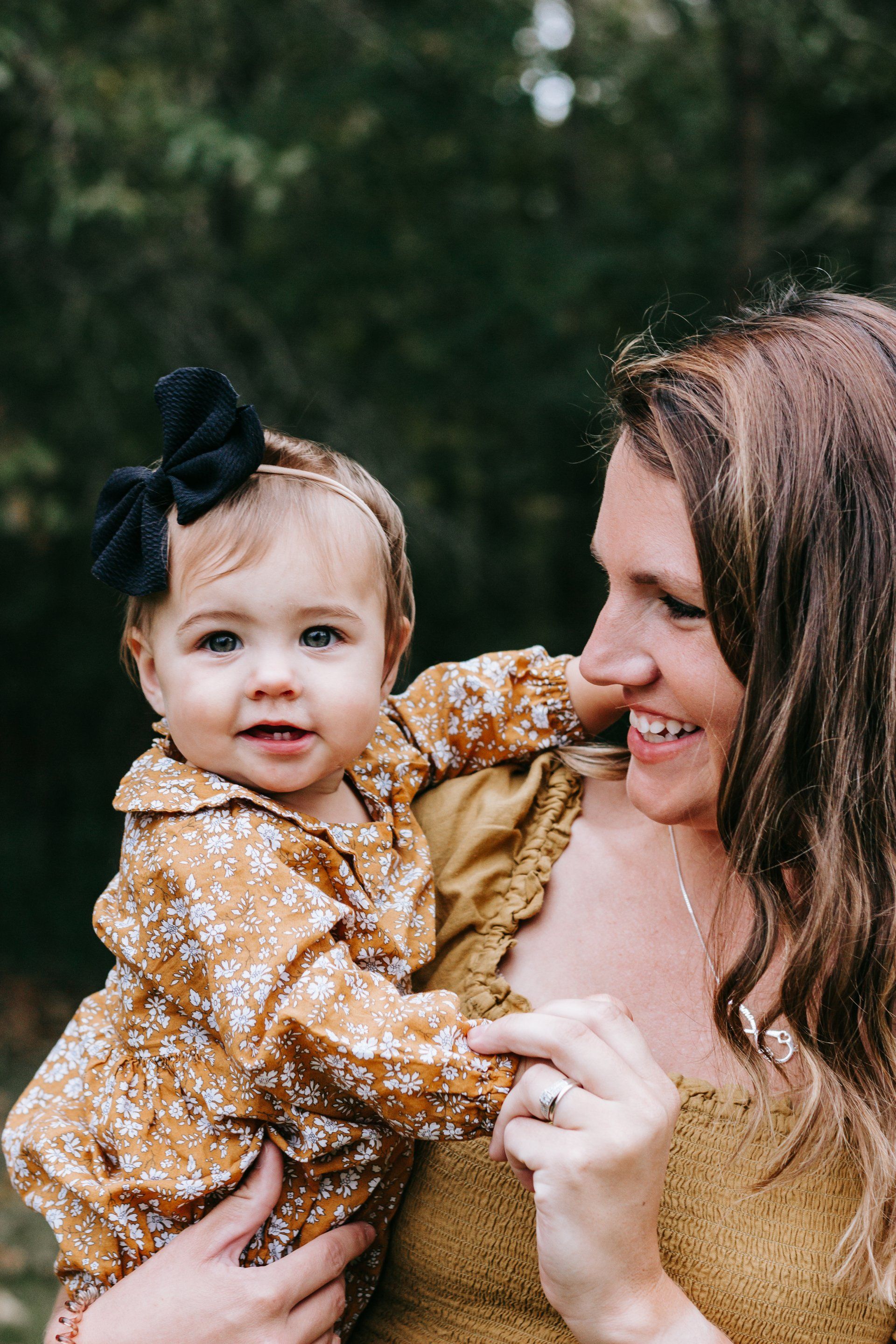 A woman is holding a baby girl in her arms.