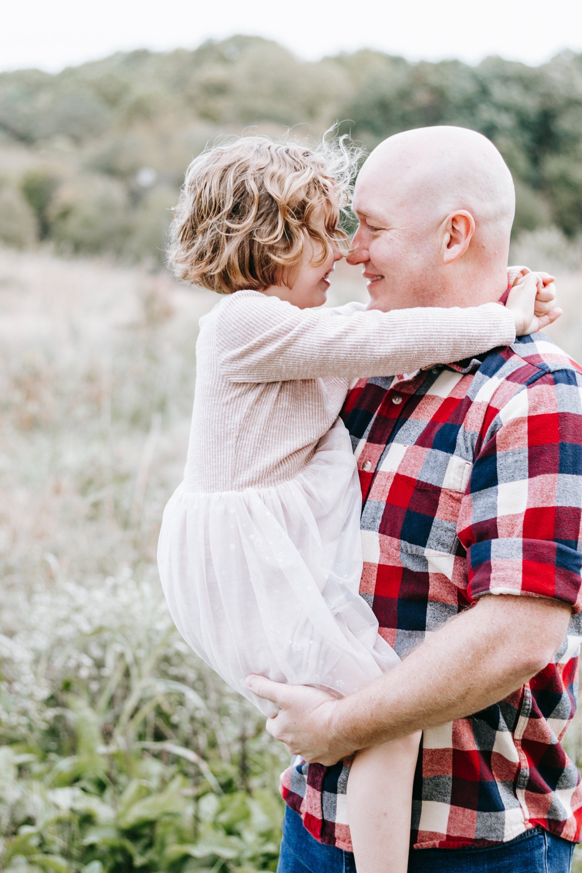 A man is holding a little girl in his arms.